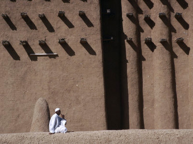 Man Sitting at Base of Mud-Brick Wall of the Grand Mosque, Djenne, Mopti, Mali